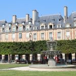 Place des Vosges (ancienne Place Royale) vue du square Louis XIII et de la fontaine au centre.